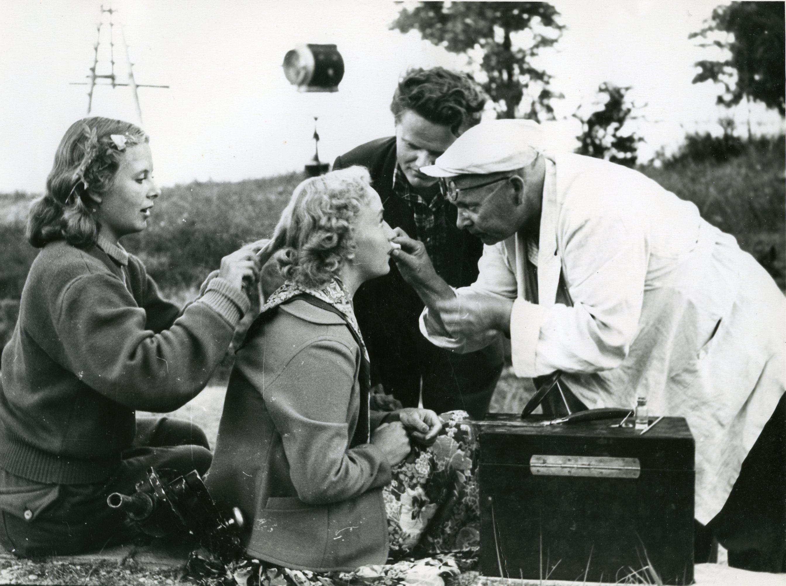 Filmivõtetel  Pärnus, Valgerannas (august 1955). Näitleja grimmeerimine - jumestaja abi Eve Kivi, Laine osatäitja  Ruth Peramets, režissööri assistent Igor Jeltsov, jumestaja-kunstnik V. Lvov - 
Foto Armin Alla

