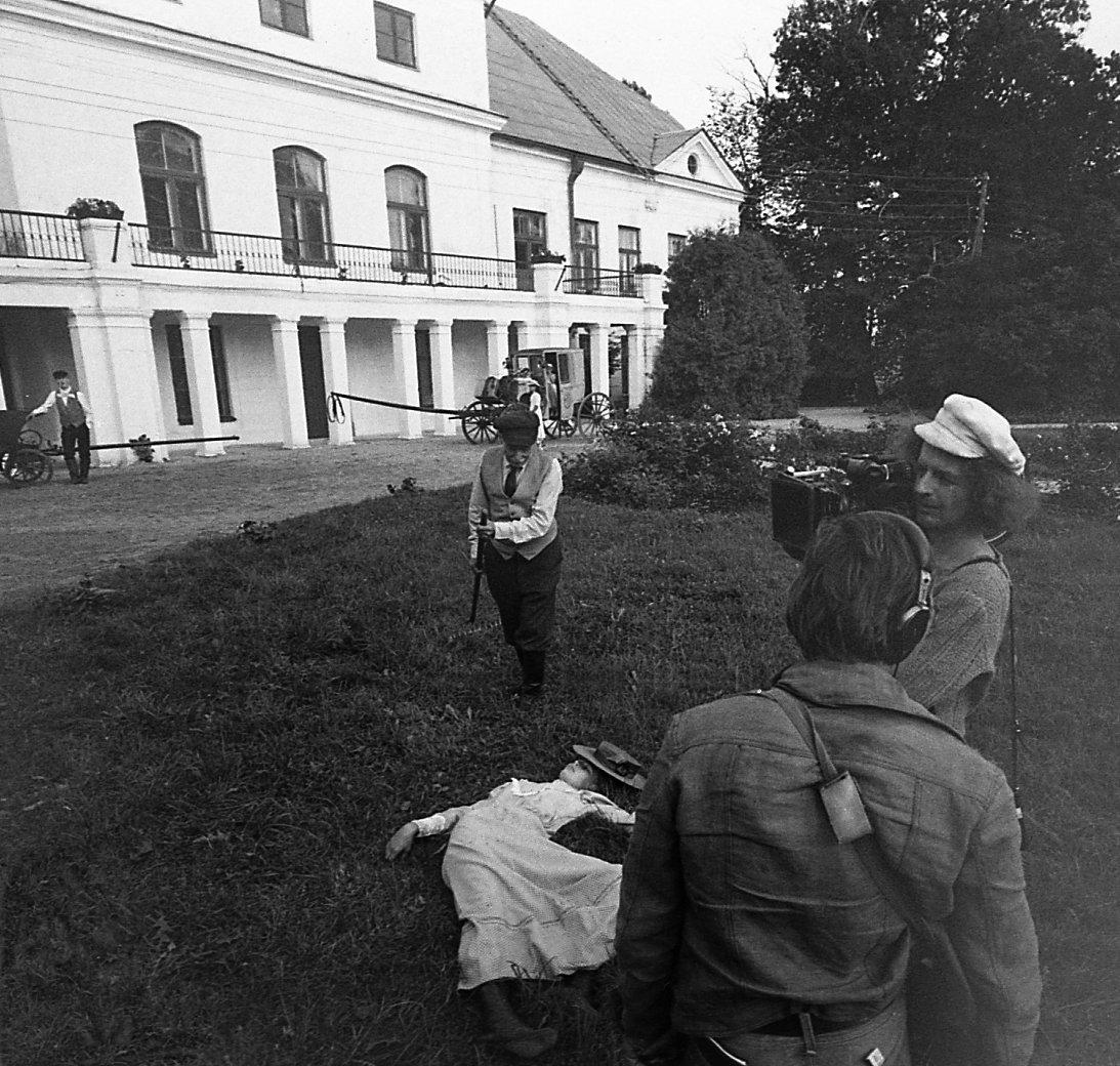Vigala koolimaja ees kutsari osatäitja Arvo Kukumägi, aedniku osatäitja Leopold Vene, maas lebab preili Julia osatäitja Julia Tommingas, seljaga helioperaatori assistent Ahti Mänd, režissöör Mark Soosaar. 